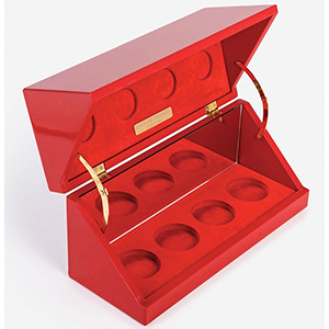 Coffret de luxe laqué rouge avec intérieur en velours, charnières dorées et emplacements circulaires pour présenter des produits