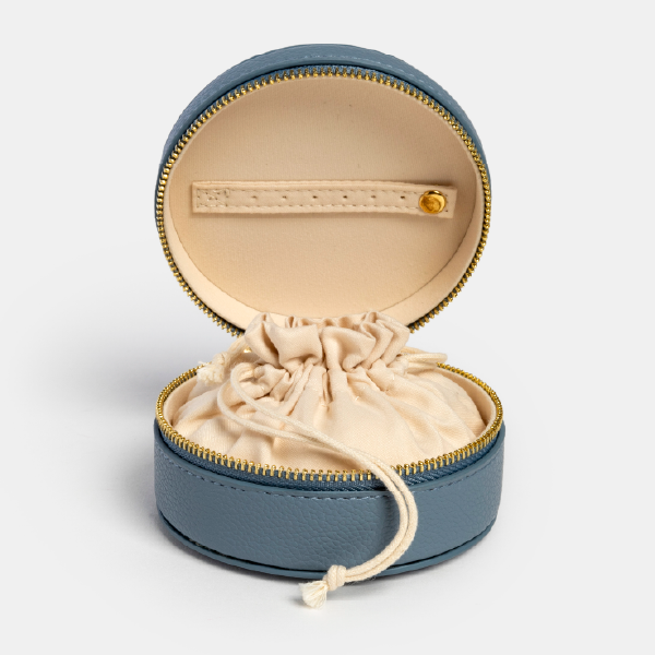 Vue de l'intérieur de la boîte à bijoux Chloé, montrant le pochon de protection en coton recyclé crème et la bande de rangement pour boucles d'oreilles dans le couvercle.