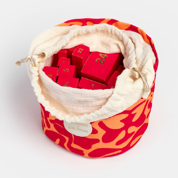 Le pochon du calendrier Bourjois ouvert, révélant les petites boîtes-cadeaux rouges numérotées à l'intérieur.