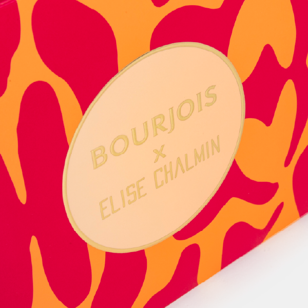 Gros plan sur l'étiquette centrale dorée de la boîte du calendrier, avec le logo "Bourjois x Elise Chalmin" embossé.