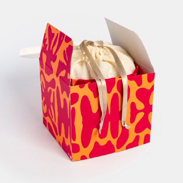 Le pochon du calendrier Bourjois présenté à l'intérieur de sa boîte extérieure cubique semi-ouverte.