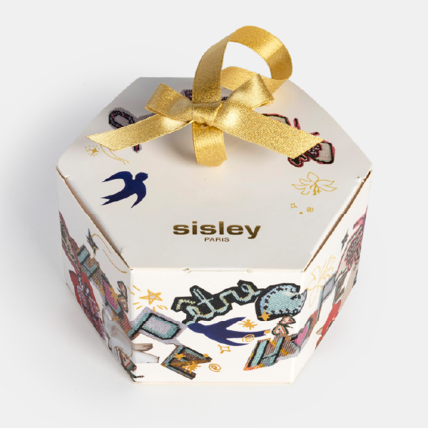 Vue d'angle du coffret cadeau hexagonal Sisley, mettant en avant le couvercle avec le logo et le ruban noué.
