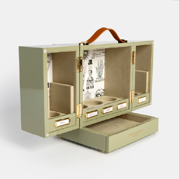 Vue de trois-quarts du coffret Penhaligon's Potions entièrement ouvert, avec ses deux portes dépliées, ses compartiments pour flacons et son tiroir inférieur sorti.