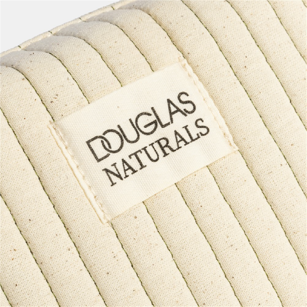 Gros plan sur l'étiquette en tissu "DOUGLAS NATURALS", cousue sur la trousse en coton GOTS matelassé.