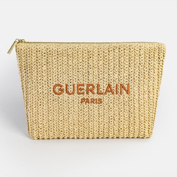 Vue de face de la trousse assortie Guerlain en Paperstraw tressé, avec le logo "GUERLAIN PARIS" brodé en fil terracotta.