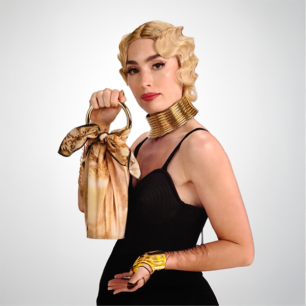 Mannequin portant le furoshiki noué sur sa bague-bijou comme un mini-sac, illustrant sa transformation en accessoire de mode.