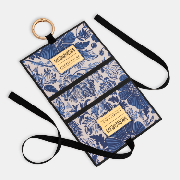 Le mini bag à motif floral bleu entièrement déplié à plat, montrant sa structure intérieure, le ruban de fermeture et l'anneau mousqueton attaché.