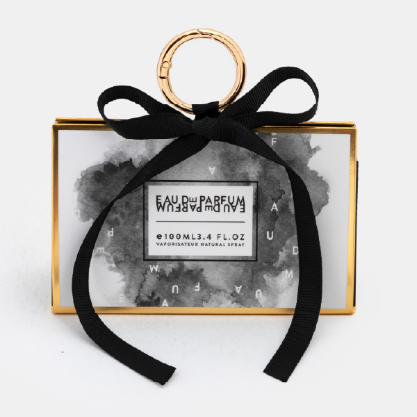 Le mini bag fermé avec un motif d'aquarelle noir et blanc, des bordures dorées, un ruban noir et un anneau mousqueton.