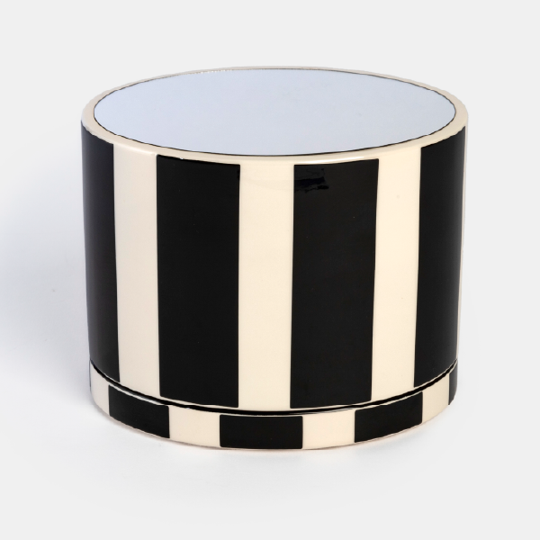 Le coffret cylindrique en bois laqué à rayures noires et blanches, vu de face en position fermée.