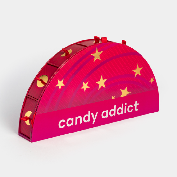 Un des trois modules du calendrier Candy Addict, en forme de demi-cercle, vu de côté. Il est de couleur rose avec des étoiles dorées et le logo "candy addict".
