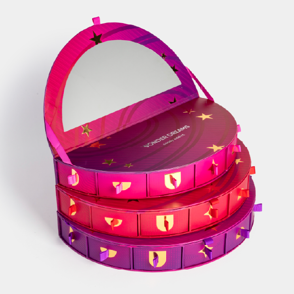 Le calendrier Candy Addict avec ses trois niveaux empilés. Le couvercle supérieur est relevé, révélant le miroir et la fonction coiffeuse.