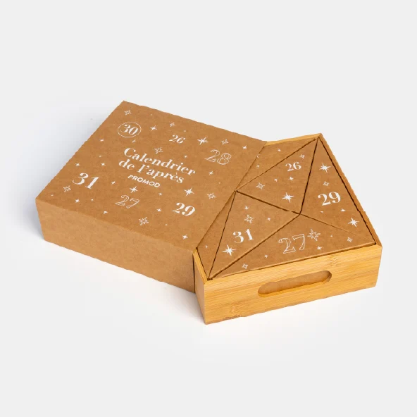 La boîte du calendrier avec son tiroir-plateau en bambou partiellement sorti, révélant les boîtes cadeaux triangulaires à l'intérieur.