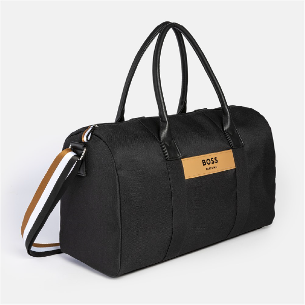 Vue de trois-quarts du sac week-end Hugo Boss, illustrant sa forme polochon, sa matière en toile noire résistante et ses finitions haut de gamme.