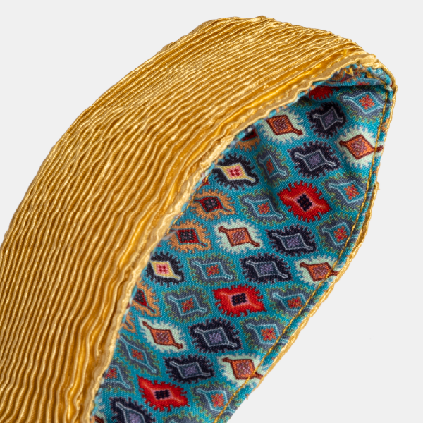 Gros plan sur l'intérieur de l'anse du sac jaune, révélant la doublure contrastante avec un motif géométrique turquoise et rouge.