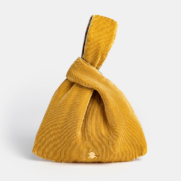 Sac à main "Kinchaku" Sisley en satin plissé jaune doré, avec son anse nouée et le monogramme de Sisley en métal.