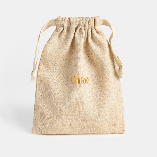 Pochon Chloé en mélange de lin et viscose beige, avec logo doré au centre et fermeture par cordons de serrage.