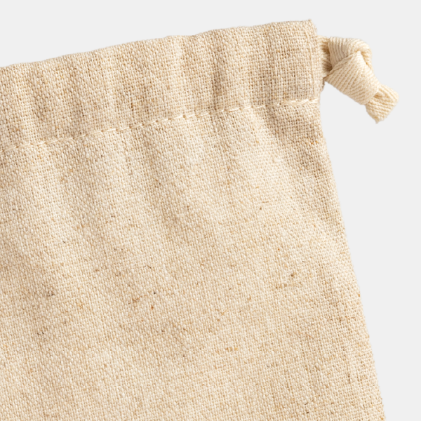Zoom sur la texture du tissu brut en lin et viscose et sur la couture du cordon de serrage du pochon Chloé, illustrant la qualité de la matière.