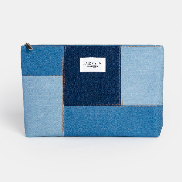Trousse plate Hair Rituel by Sisley, conçue avec un assemblage de denim patchwork en plusieurs teintes de bleu et une étiquette logo blanche centrale.