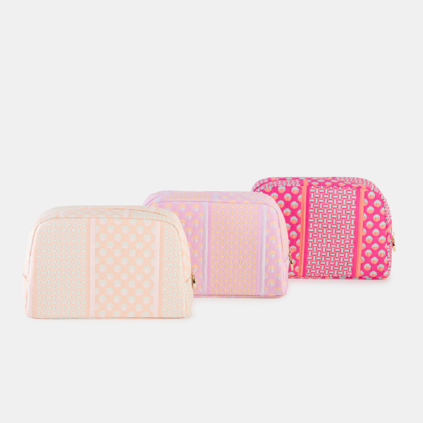 Trois trousses de toilette Bulgari en tissu Jacquard éco-conçu, présentées en trois déclinaisons de couleurs : pêche, rose et fuchsia.