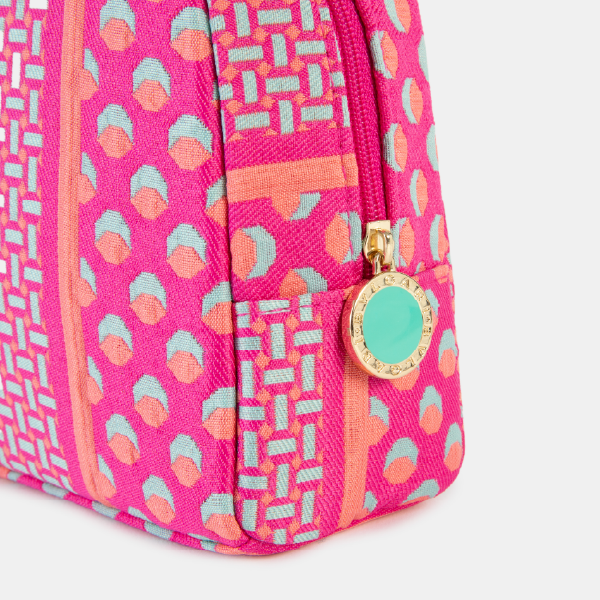Gros plan sur la fermeture éclair dorée de la trousse Jacquard fuchsia, avec son médaillon rond siglé Bulgari et un centre turquoise, soulignant la qualité de fabrication.
