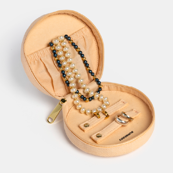 Vue complète de la trousse à bijoux Burberry ouverte, montrant les différents compartiments de rangement en coton recyclé avec des bijoux à l'intérieur.