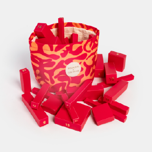 Calendrier de l'Avent innovant avec des blocs rouges numérotés, présenté dans un article sur les cadeaux de fin d'année de luxe conçus par Anaïk.