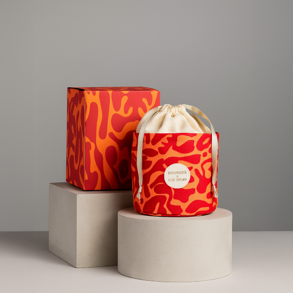 Le pochon réutilisable et sa boîte extérieure du calendrier de l'Avent Bourjois x Elise Chalmin, présentés sur des podiums.