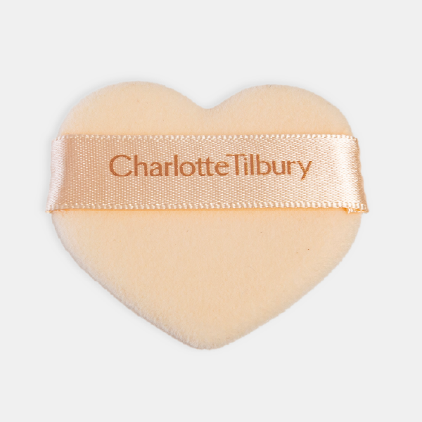 Vue de dessus de la houppette en forme de cœur, montrant clairement le logo Charlotte Tilbury imprimé sur le ruban de satin.