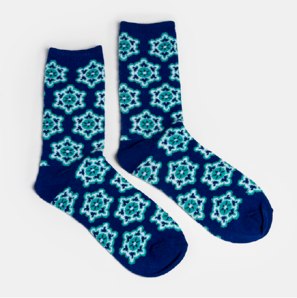 Vue à plat de la paire de chaussettes bleues Glowria, montrant l'intégralité du motif jacquard d'inspiration ski rétro sur toute la hauteur.