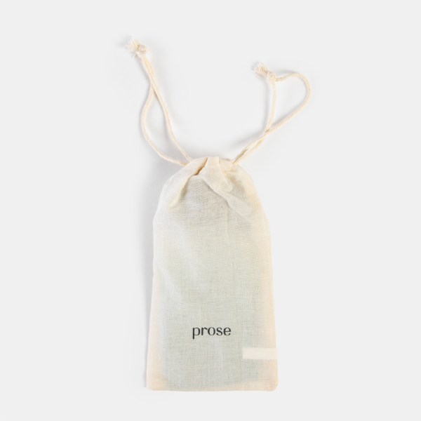 La pochette de rangement en coton GOTS certifié, de couleur crème et avec cordon, fermée pour contenir le kit de voyage Prose.