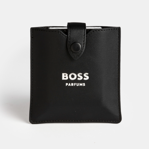 Vue de face du porte-cartes noir pour le jeu de cartes BOSS Parfums, fermé par son bouton pression et affichant le logo argenté.