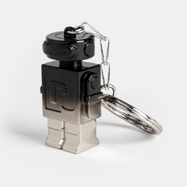 Vue de trois-quarts du porte-clé robot Phantom en alliage de zinc, soulignant le reflet sur sa finition dégradée allant du noir au gris métallisé.