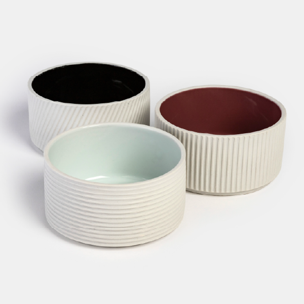 Ensemble de trois coupelles en porcelaine de la collection Anaïk Portugal, chacune avec une texture extérieure et une couleur intérieure laquée différente.