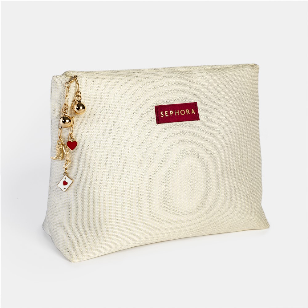 Une pochette accessoirisée de charms, où le détail décoratif vient enrichir l’objet et prolonger l’expérience de marque.