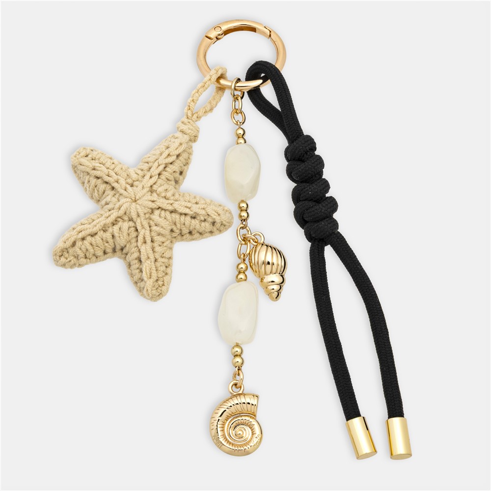 Un porte-clés décoratif aux matières contrastées, mêlant textile et éléments métalliques pour un rendu premium et différenciant.